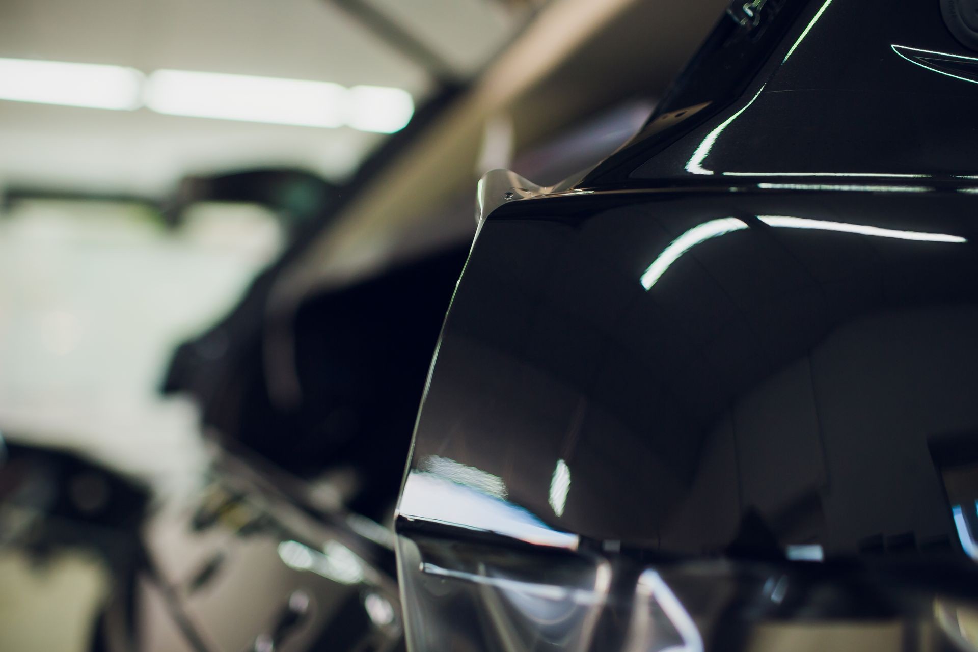 Worker hands installs car paint protection film wrap. Worker hands installs car paint protection film wrap.